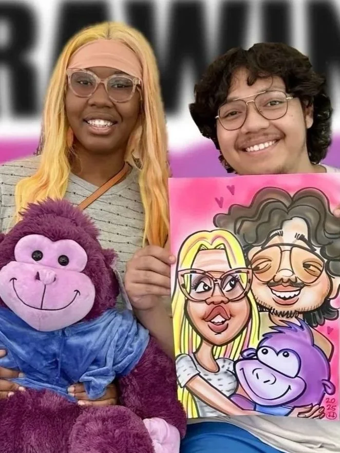 Couple holding a colorful caricature of themselves at a fun event, with a purple stuffed monkey toy in the foreground.
