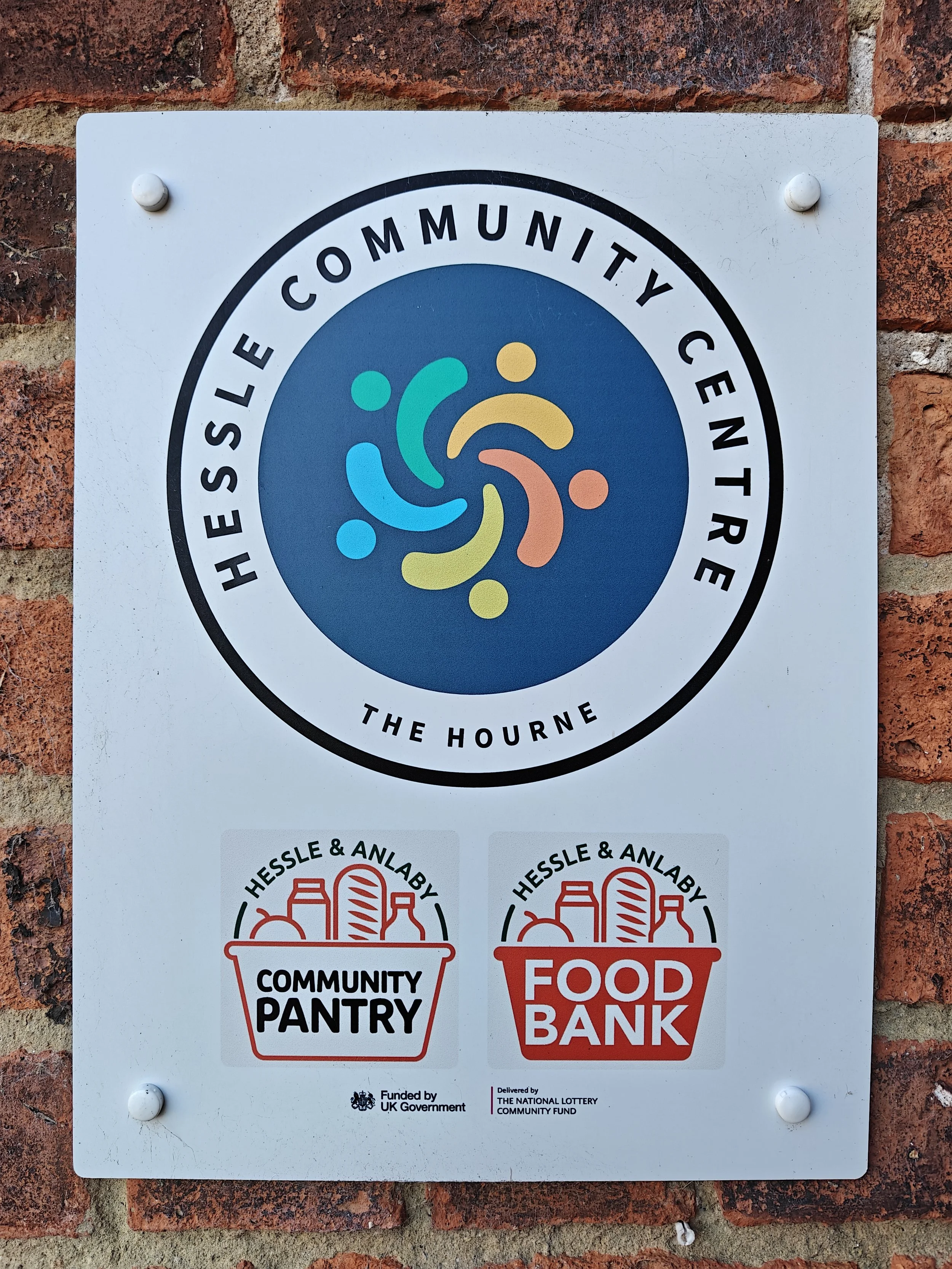 Sign for Hessle Community Centre, featuring logos for community pantry and food bank.