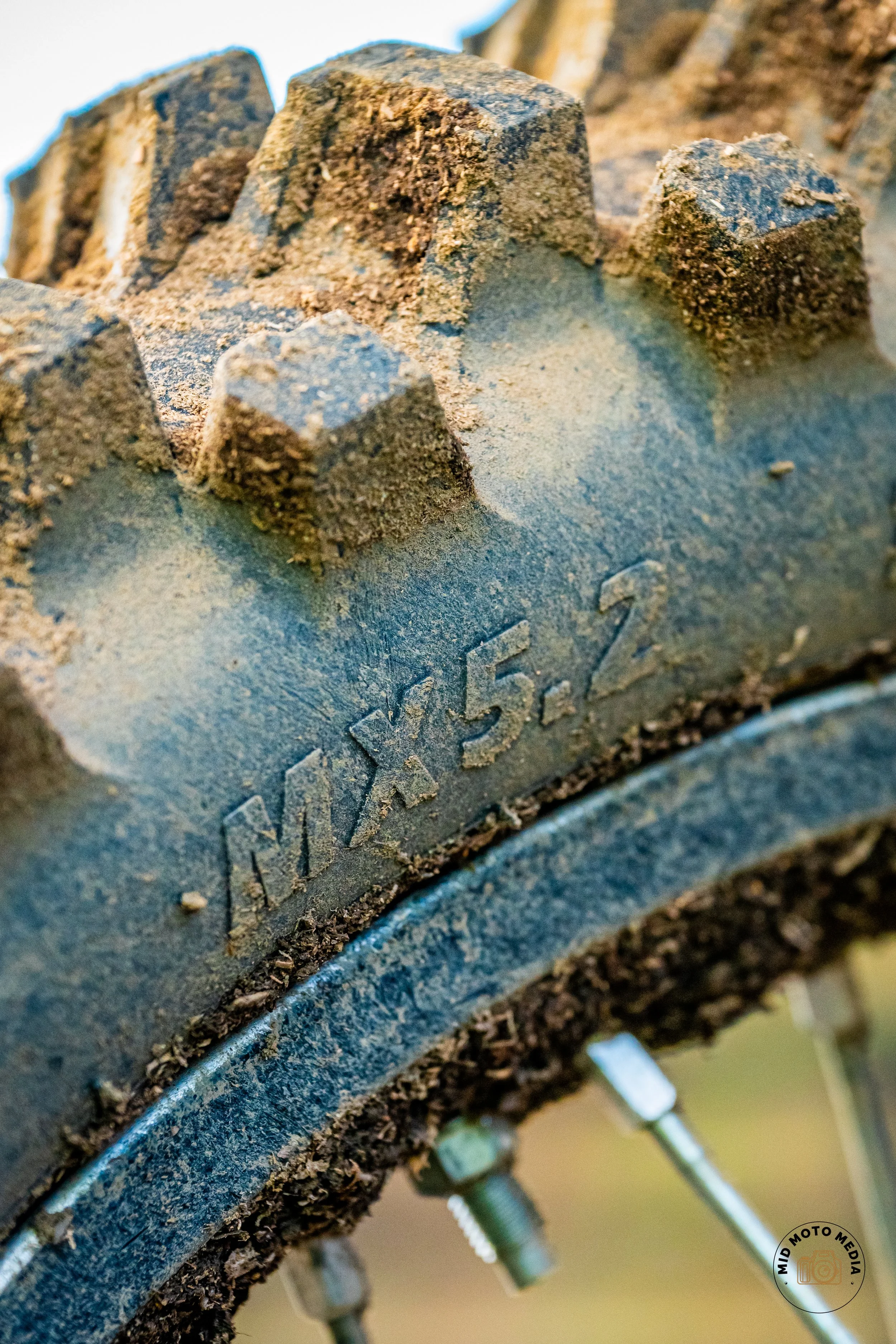 Close-up of a dirt-covered tire with the marking 'MDX 5.2' on its sidewall.