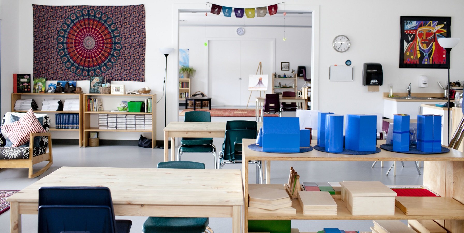 Bright Montessori classroom with wooden tables, chairs, and learning materials at Skyridge Montessori.