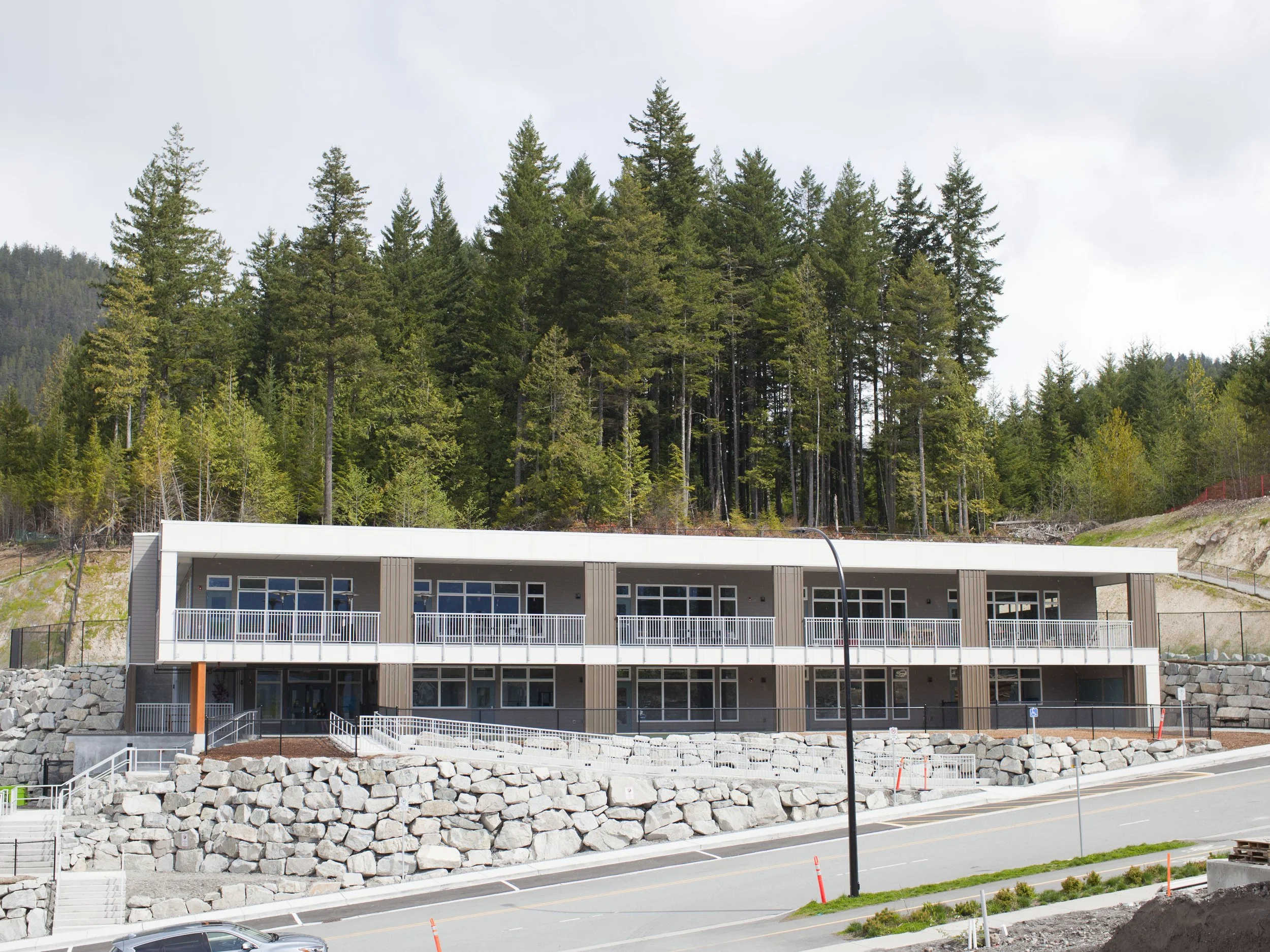 Exterior view of the Skyridge Montessori school building in Squamish, surrounded by trees and mountains.