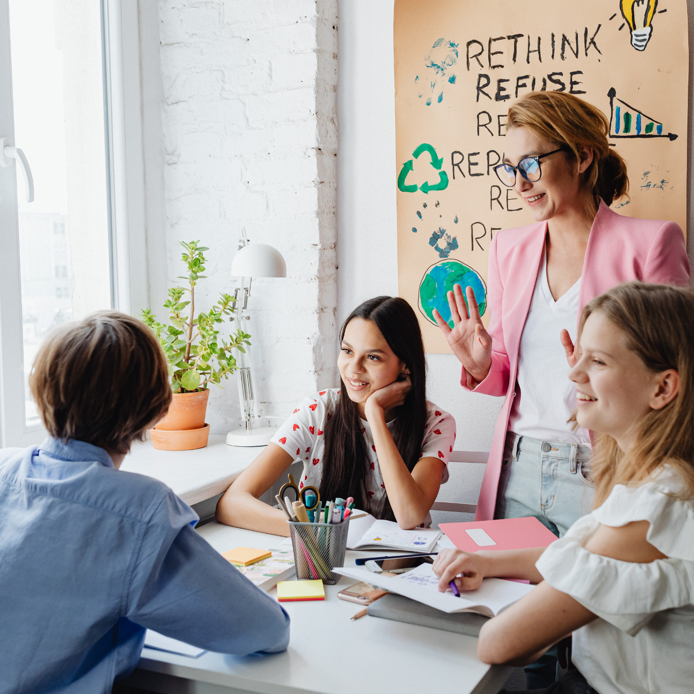 Teacher leading a small group discussion with students during a collaborative classroom lesson.