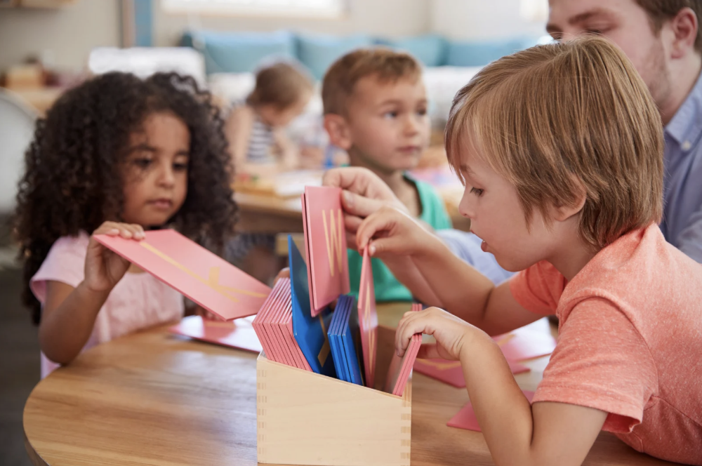 Children using Montessori letter cards during a hands-on early literacy activity.