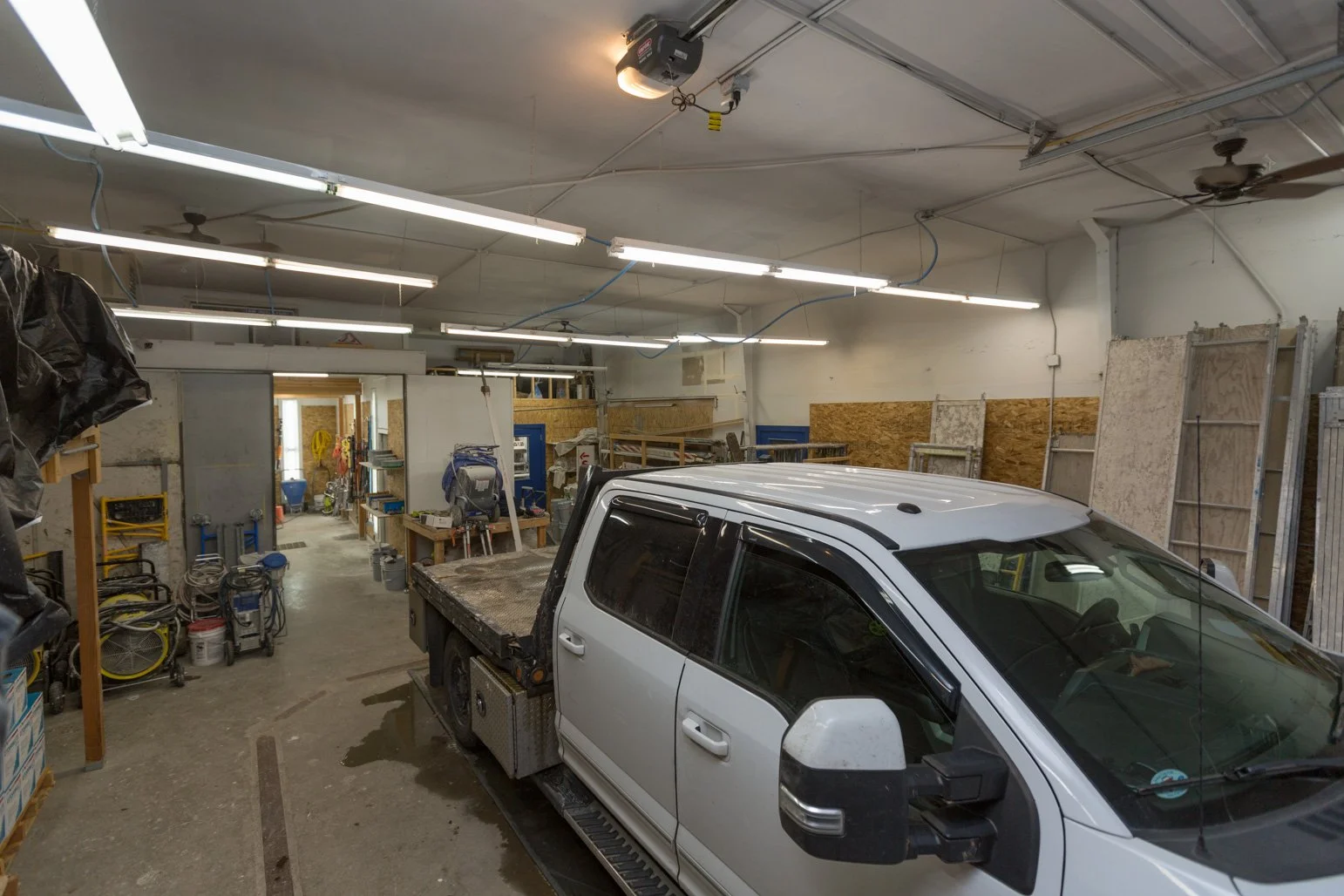Olbricht's pickup truck parked inside a garage with various tools, shelves, and construction materials.