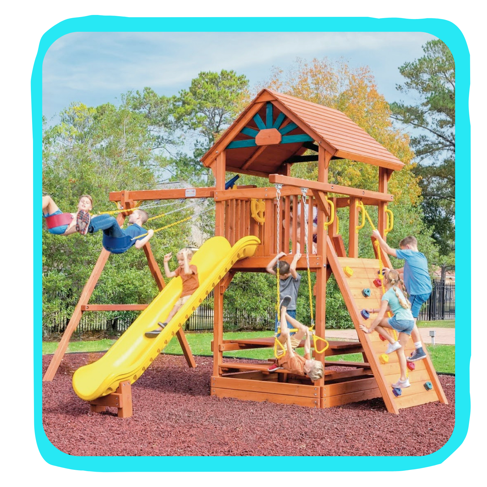 Children playing on a wooden playground set with slides, swings, and climbing walls outdoors with trees in the background.