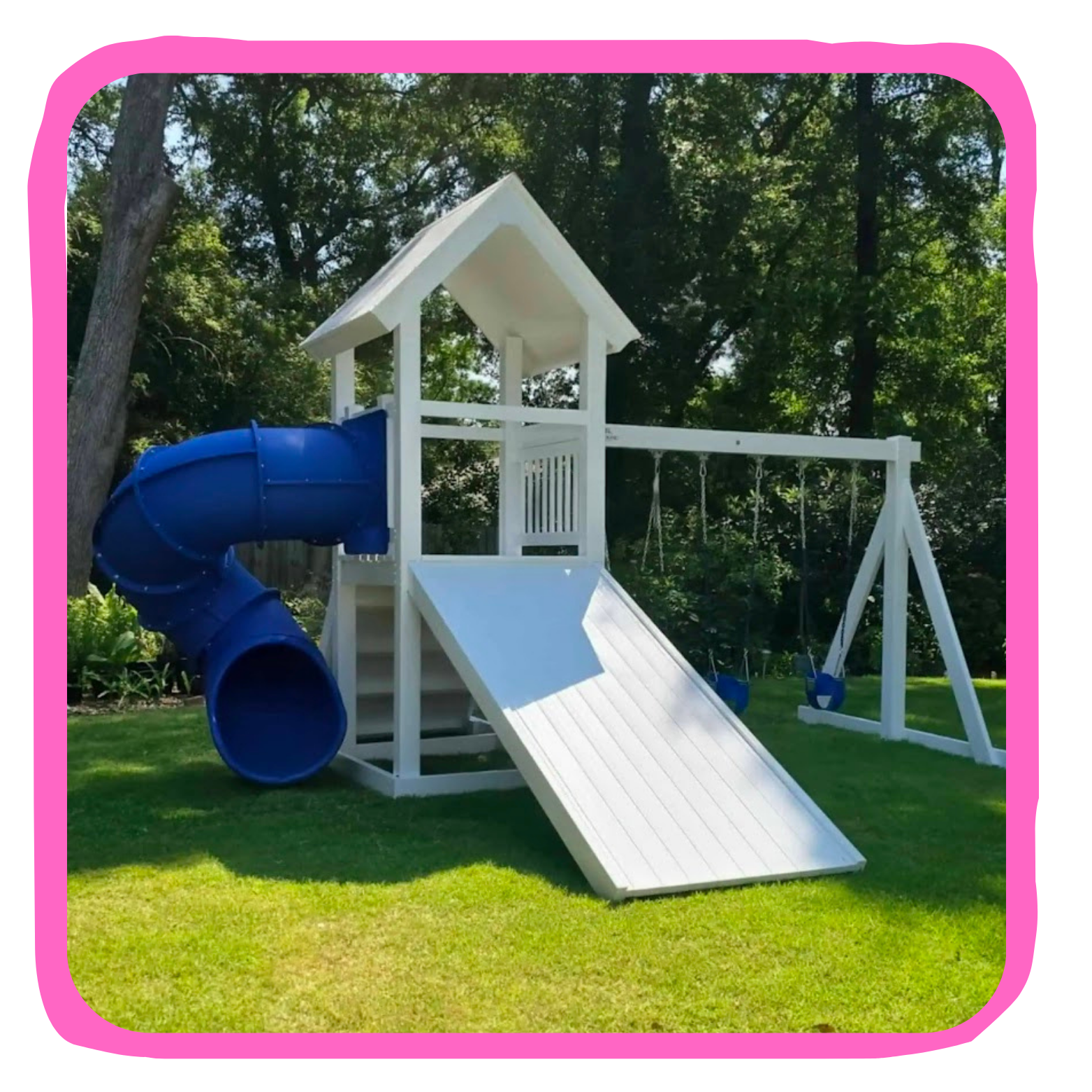 A white wooden outdoor playset with a blue spiral slide, a small roofed platform, two hanging swings, and a slide on a grassy backyard with trees in the background.
