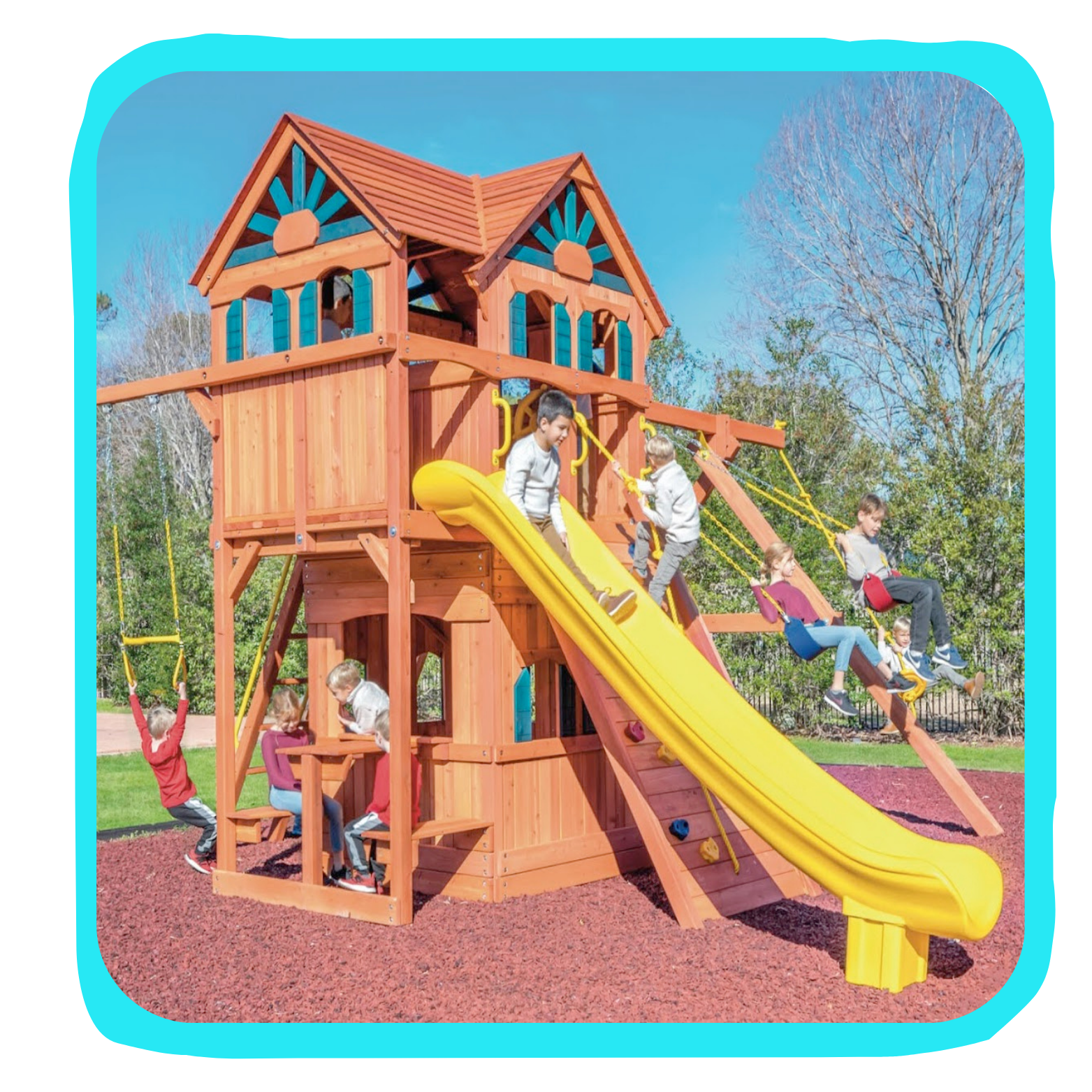 Children playing on a large wooden playground with a yellow slide, swings, and a playhouse, on a sunny day.