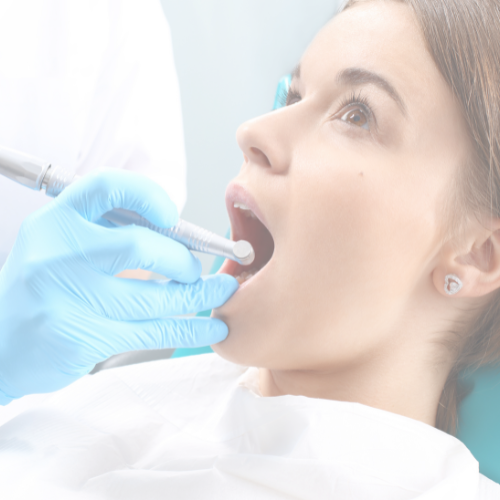 Dentist examining a patient's open mouth with dental tools in a dental clinic.