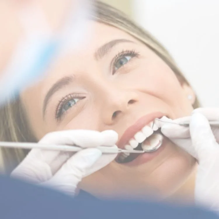 A woman at the dentist's office getting her teeth examined.