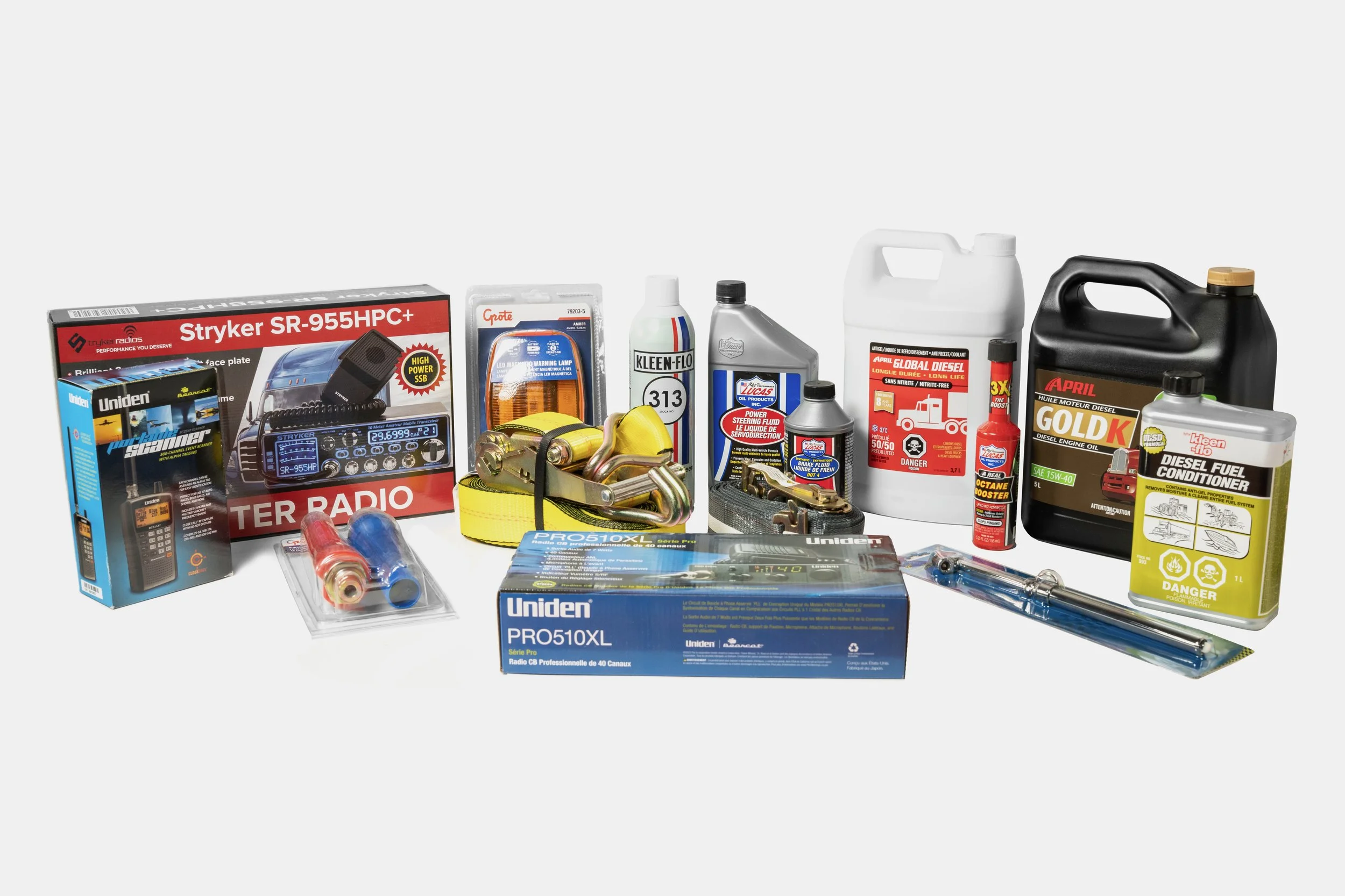 Une collection d'outils et de produits pour l'entretien et la réparation automobile, incluant un détecteur de radio CB, des câbles de démarrage, des flasques de fluides, des produits d'huile moteur, et divers équipements de sécurité.