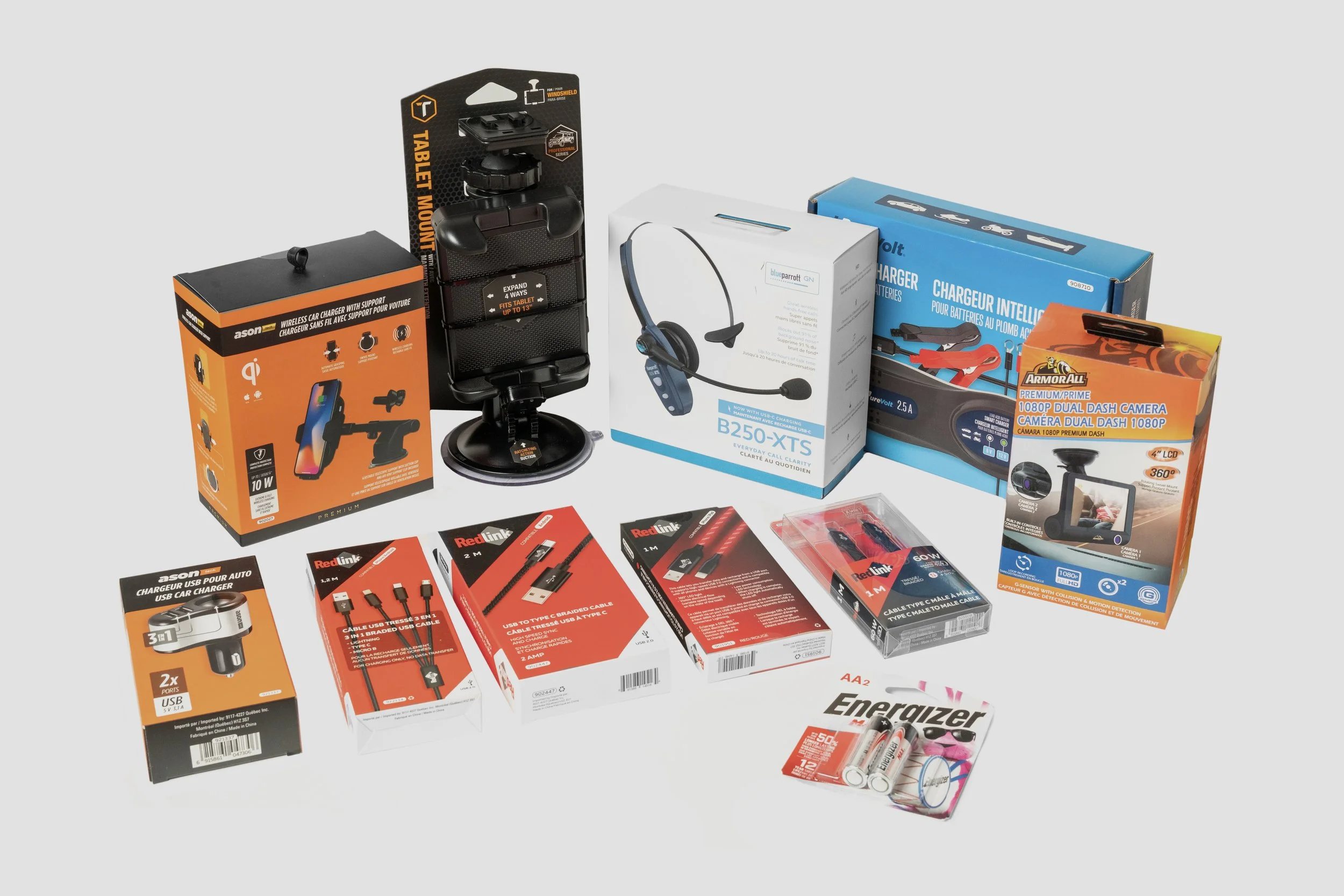 Une collection de gadgets électroniques et accessoires, incluant un support de téléphone, des câbles de recharge, une caméra de tableau de bord, une pile rechargeable, et autres produits technologiques.