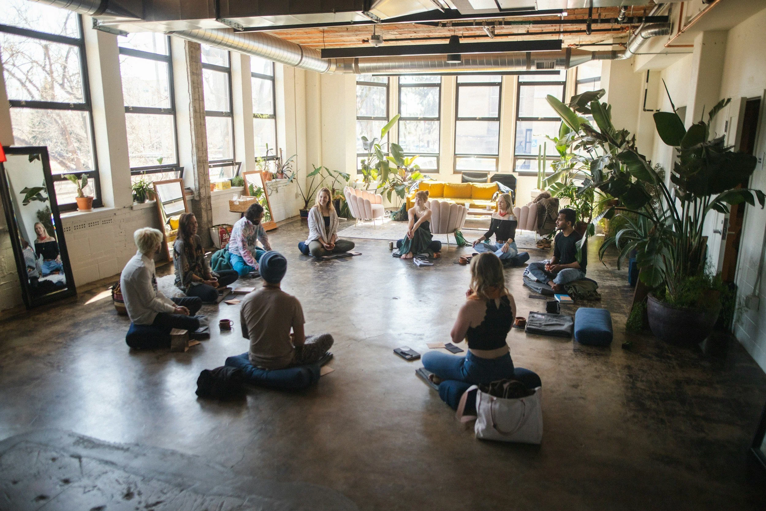 Group of apartment residents participating in a guided meditation in a shared community space.