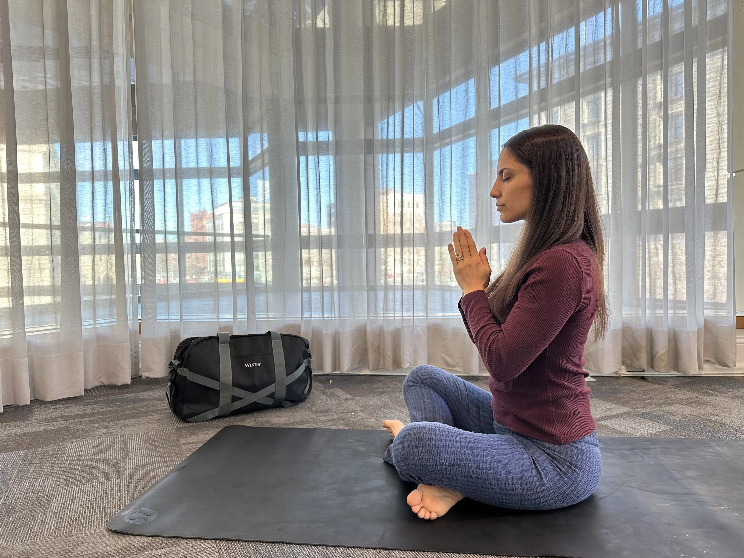 ThriveHub Founder and CEO Ali Singer in sukhasana pose at the Westin hotel during a hotel wellness program.