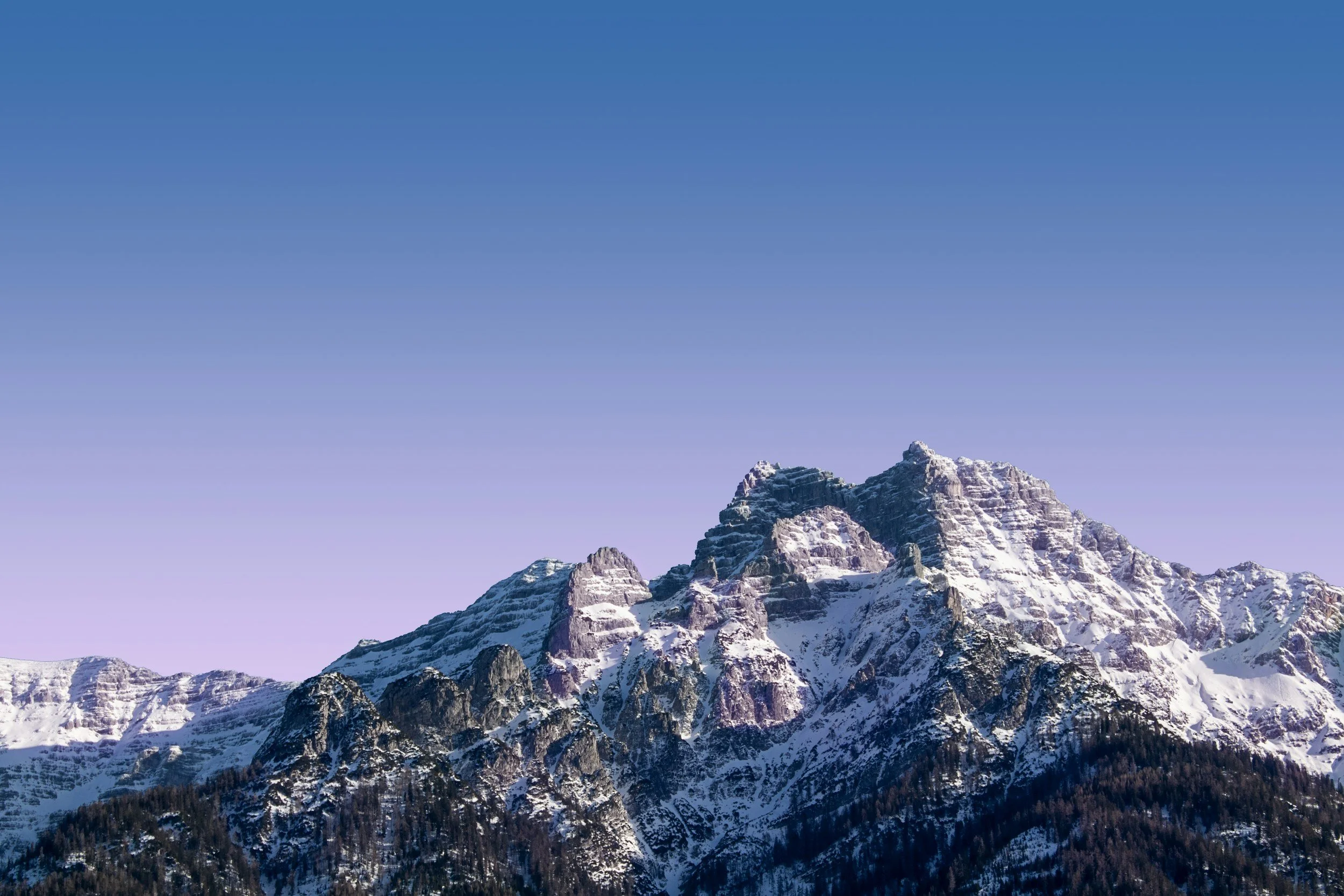 Snow-covered mountain peaks under a clear blue sky.
