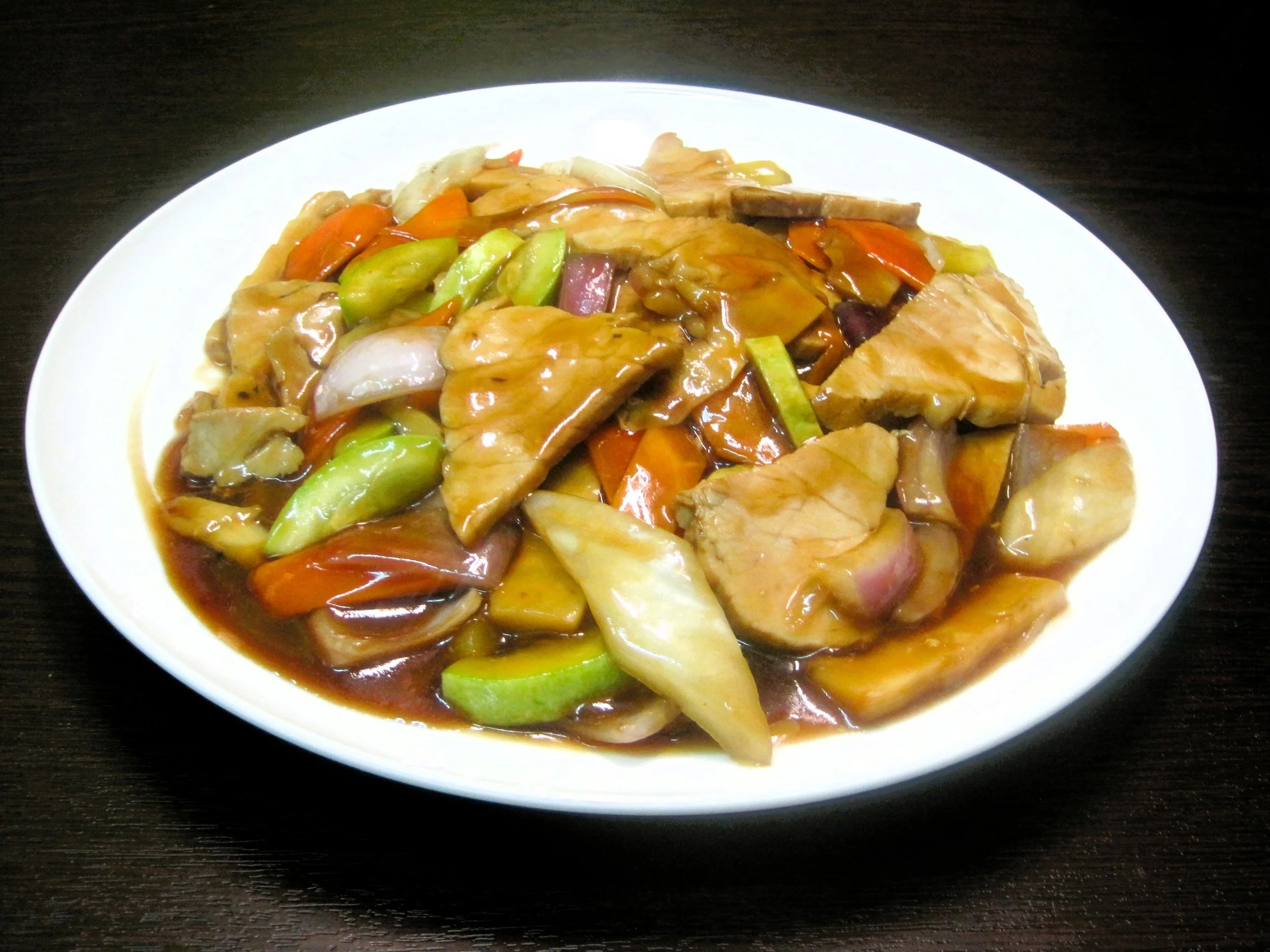 Plate of stir-fried chicken with vegetables in sauce.