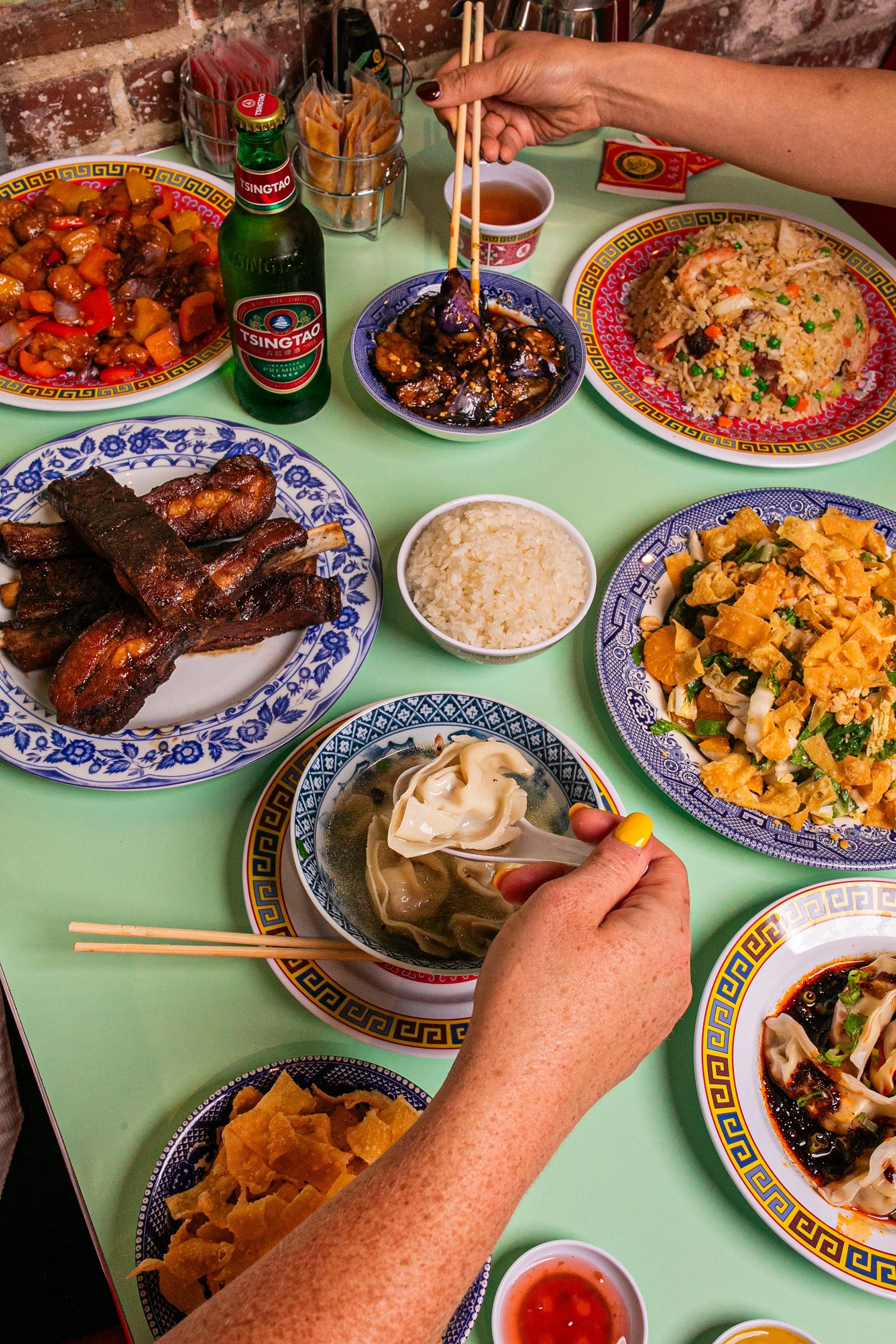 Hands reaching for food on a table at The Majestic