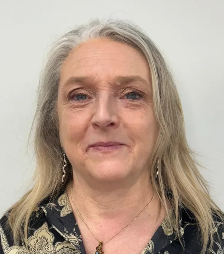 Headshot of Heather Dixon with long hair, wearing earrings