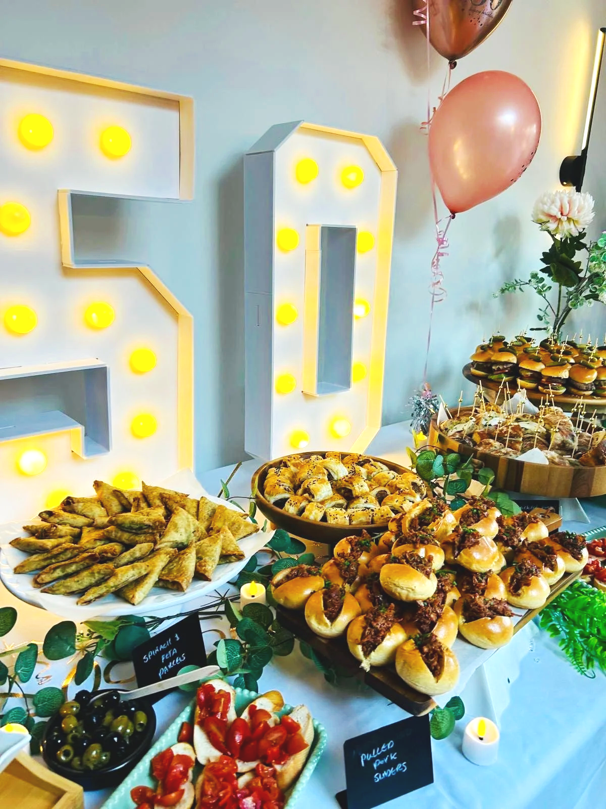 50th birthday grazing table spread with mini burgers and canepes