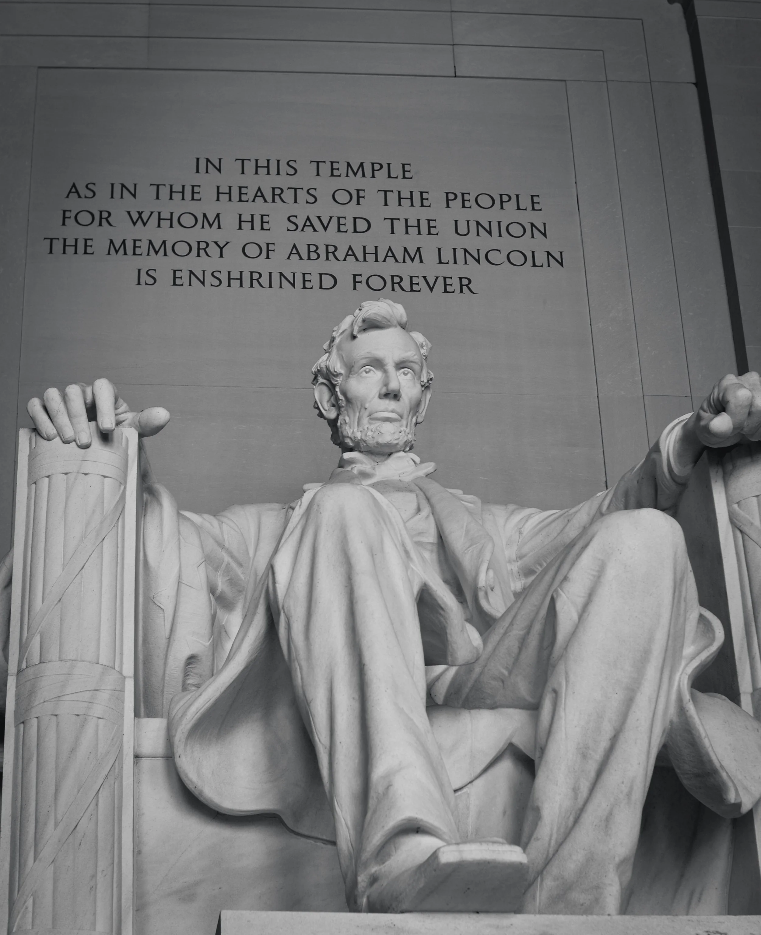 Close-up of the Abraham Lincoln Memorial sculpture with an inscription about Abraham Lincoln above it.