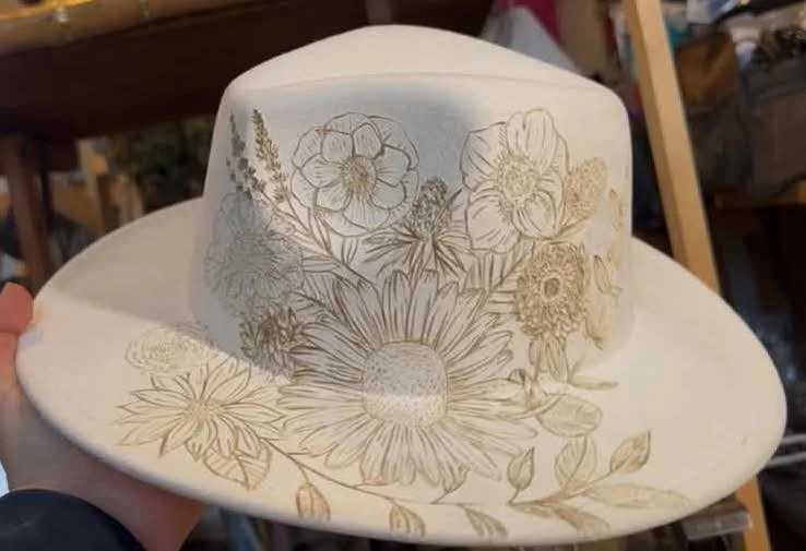 hand burned custom hat for a bride on a ivory rancher fedora using the flowers from he bouquet