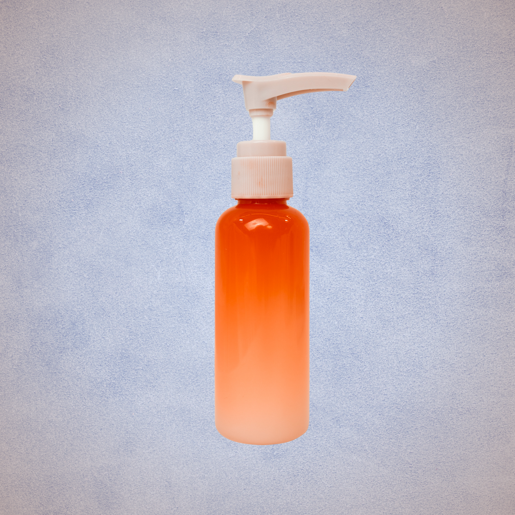 Orange pump bottle with a pink dispensing nozzle on a light blue textured background.