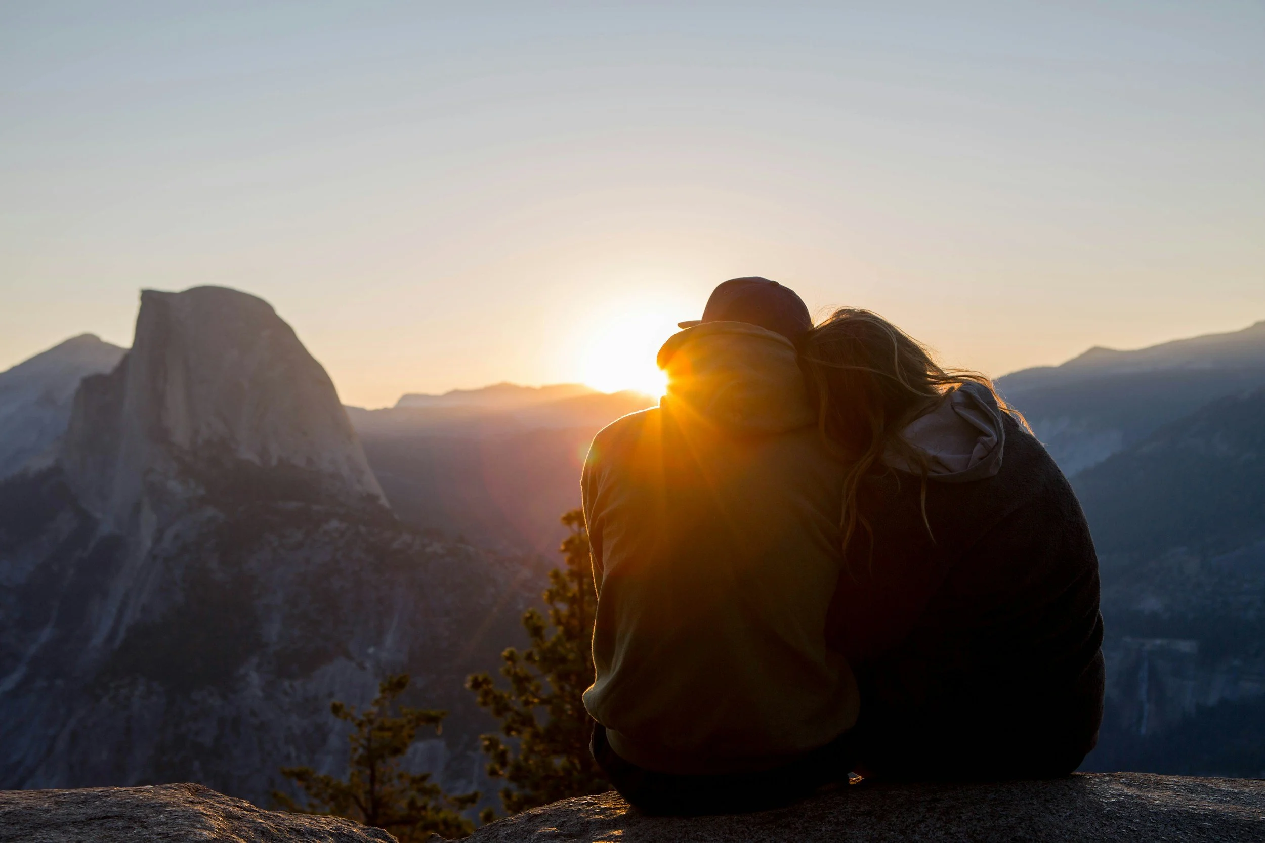Couple sitting together at sunset in nature, representing infertility therapy, infertility counseling, and infertility support