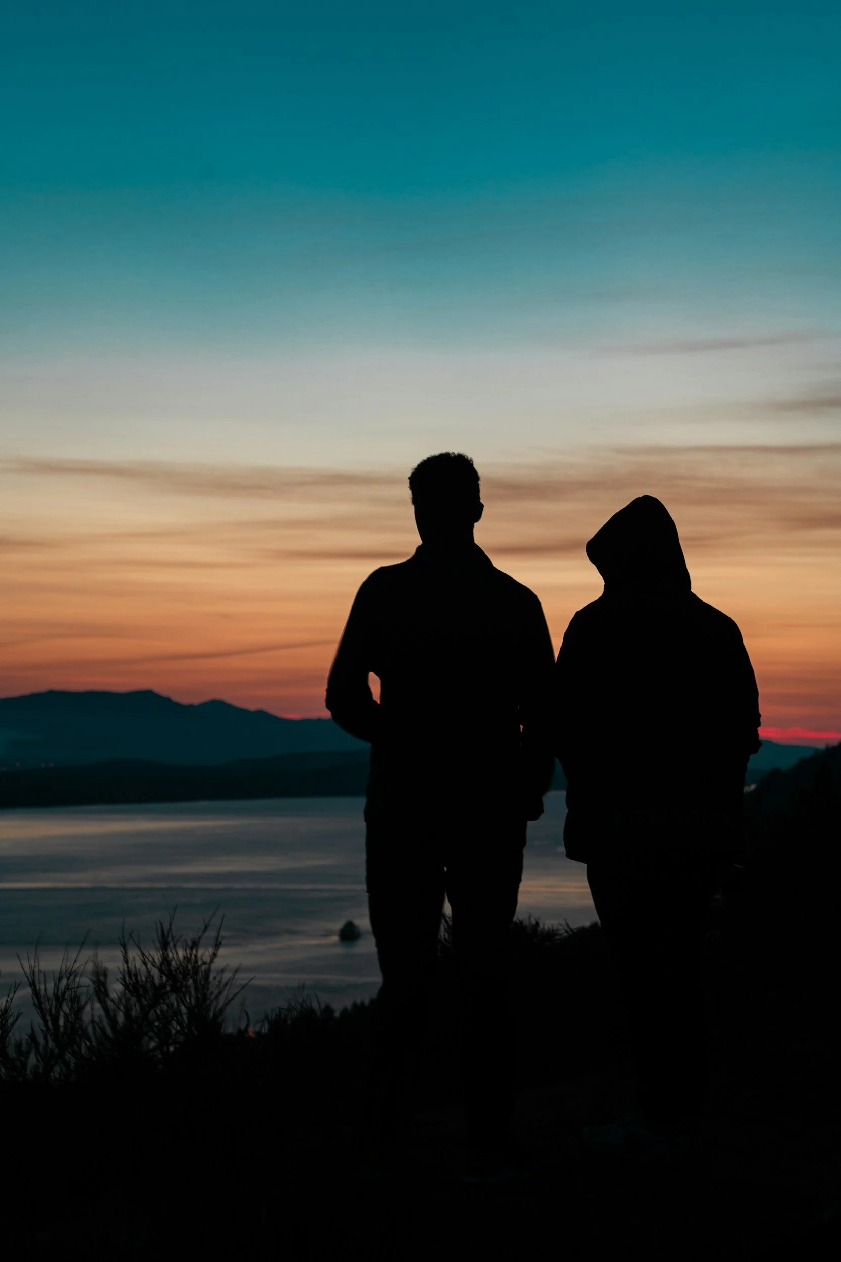 Couple standing together in nature at sunset, representing gender identity therapy, gender affirming therapy and the importance of supportive relationships during identity exploration.
