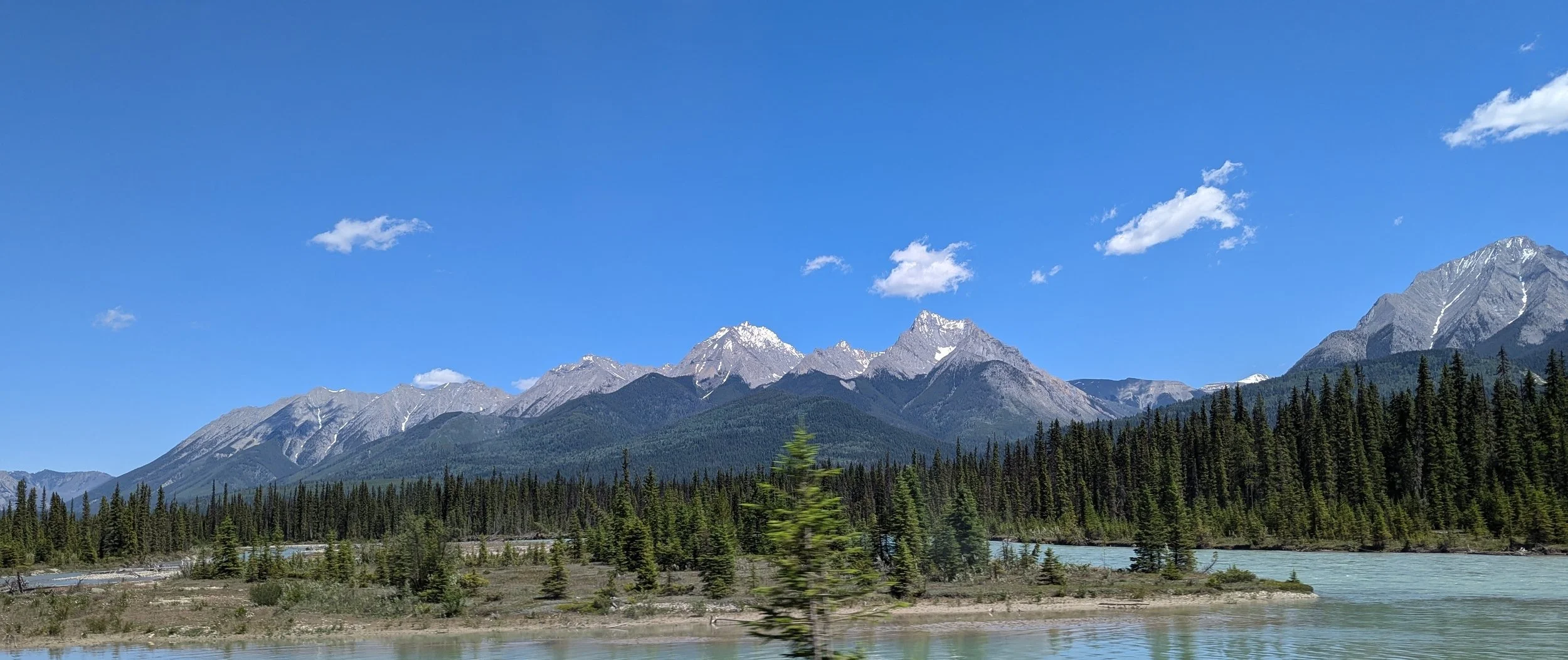 Lucy Quach Counselling & Psychotherapy - mountain range 1 with trees and sunny sky