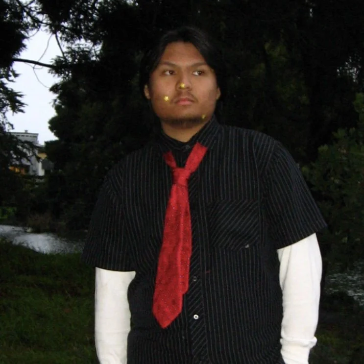 Ethan Zamora wearing a black shirt and red tie over a white long sleeve
