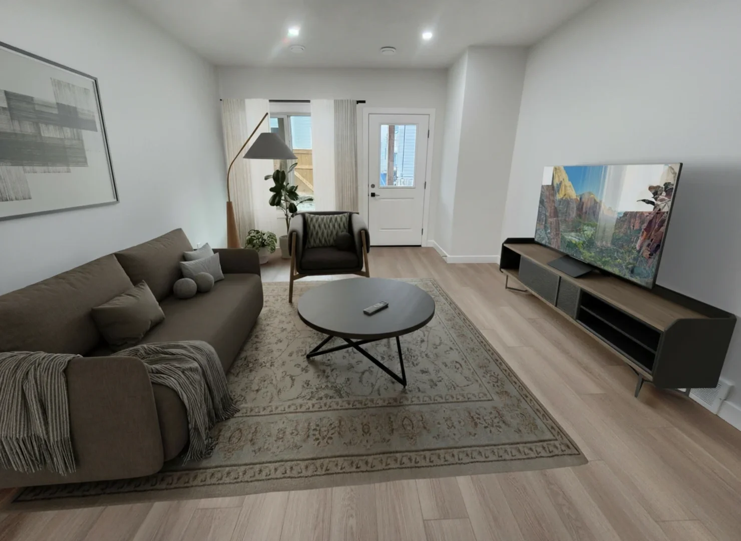 A modern living room featuring a brown sofa, a large television on a sleek console, and a patterned area rug over light wood floors.
