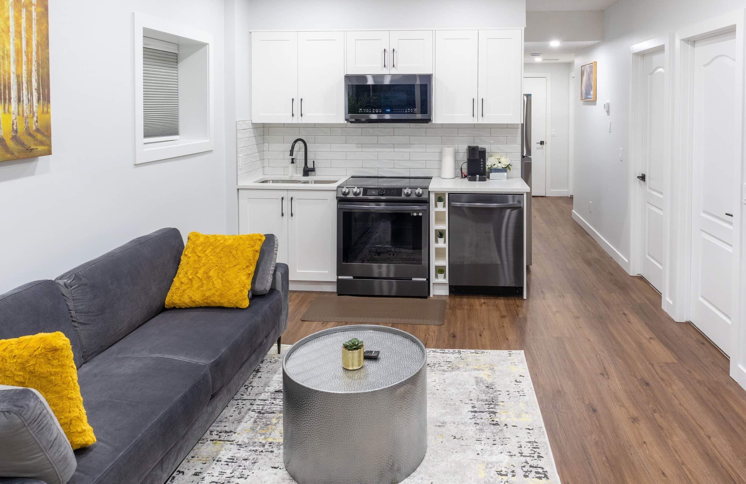 grey-velvet-sofa-yellow-pillows-white-kitchenette-hammered-silver-table.jpg
