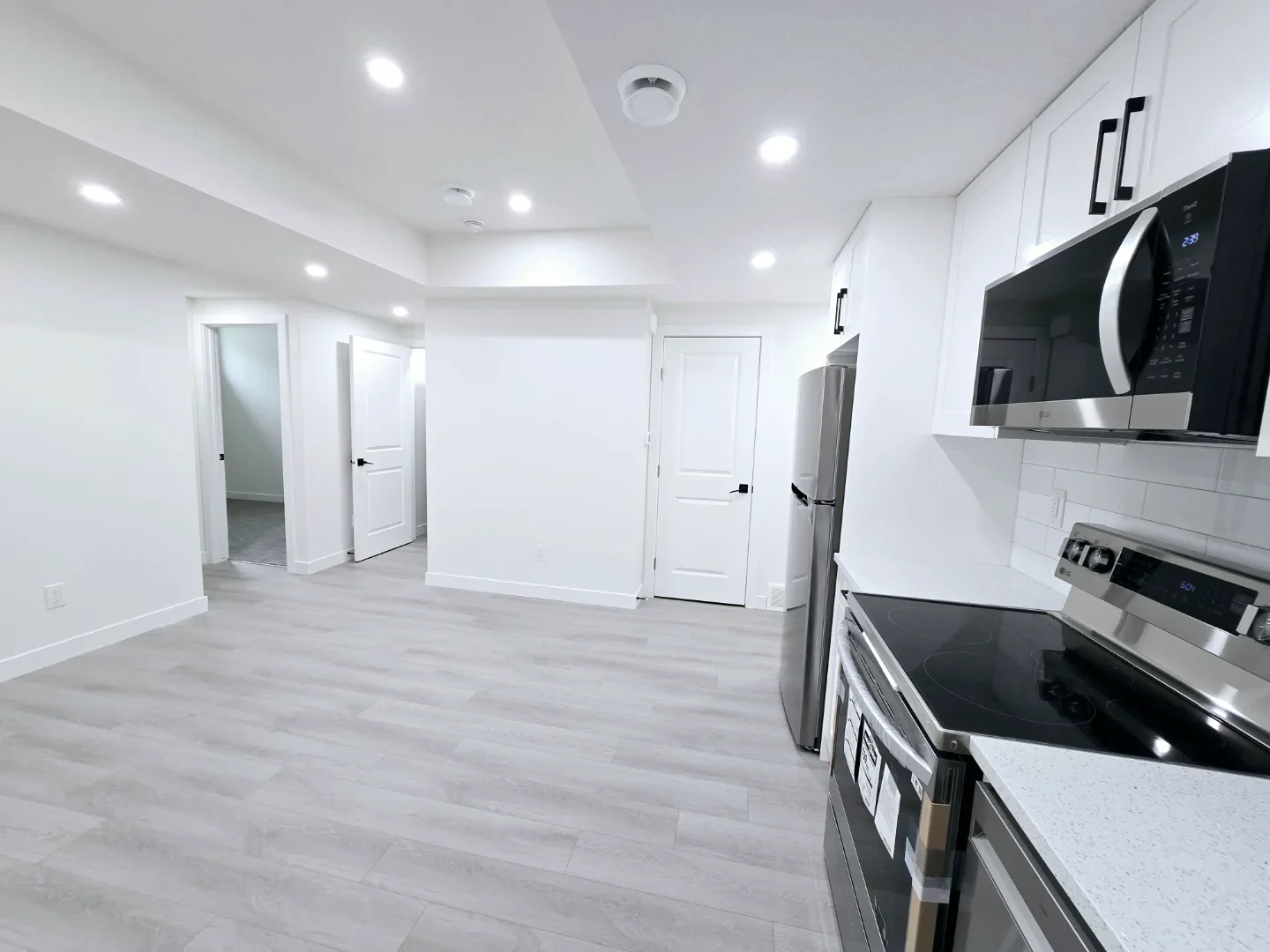 Interior view of the suite showing the transition from the kitchen to the bedroom hallways with clean white doors and trim.