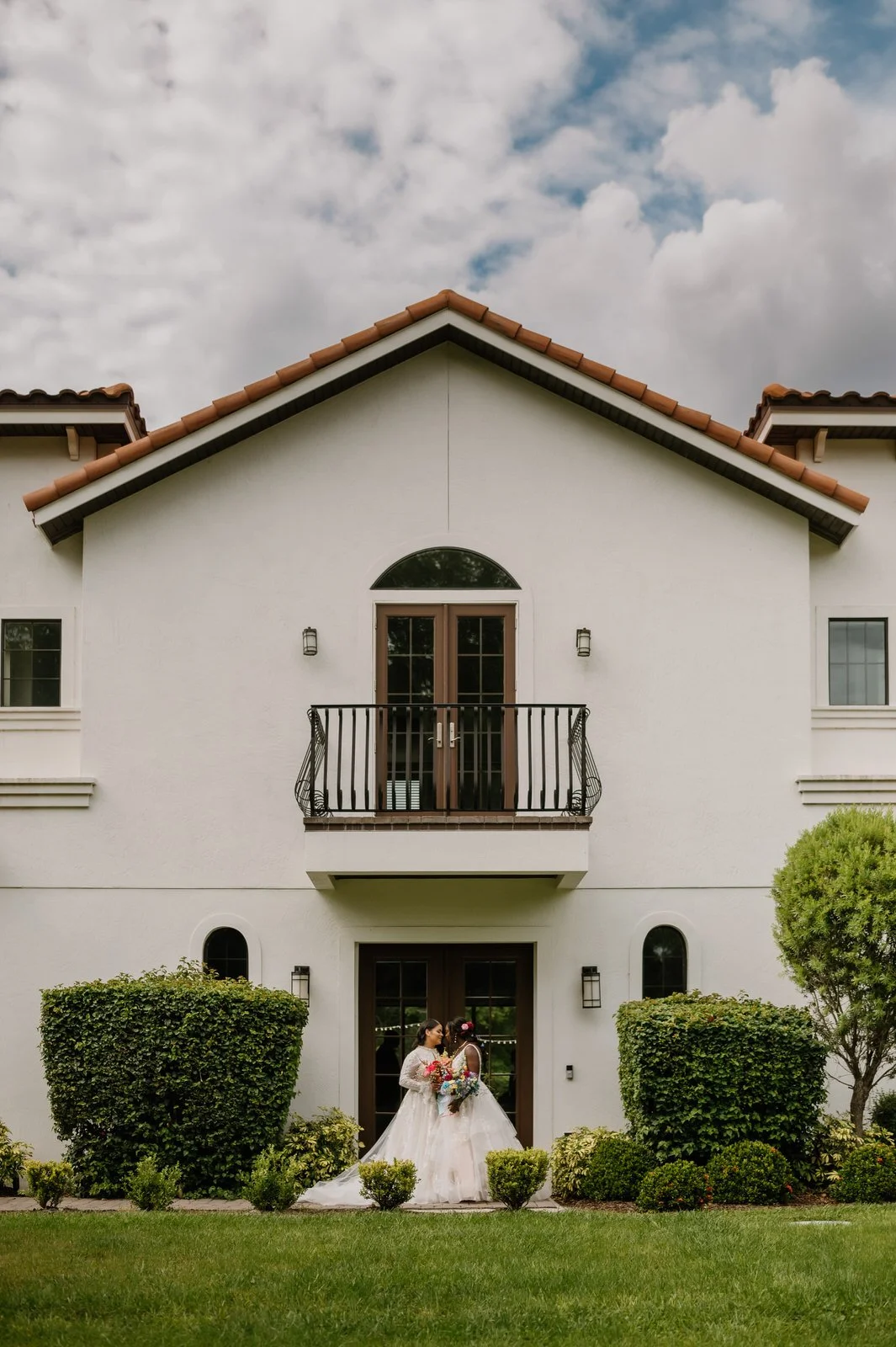 two brides outside of the secret garden at paradise spring wedding venue