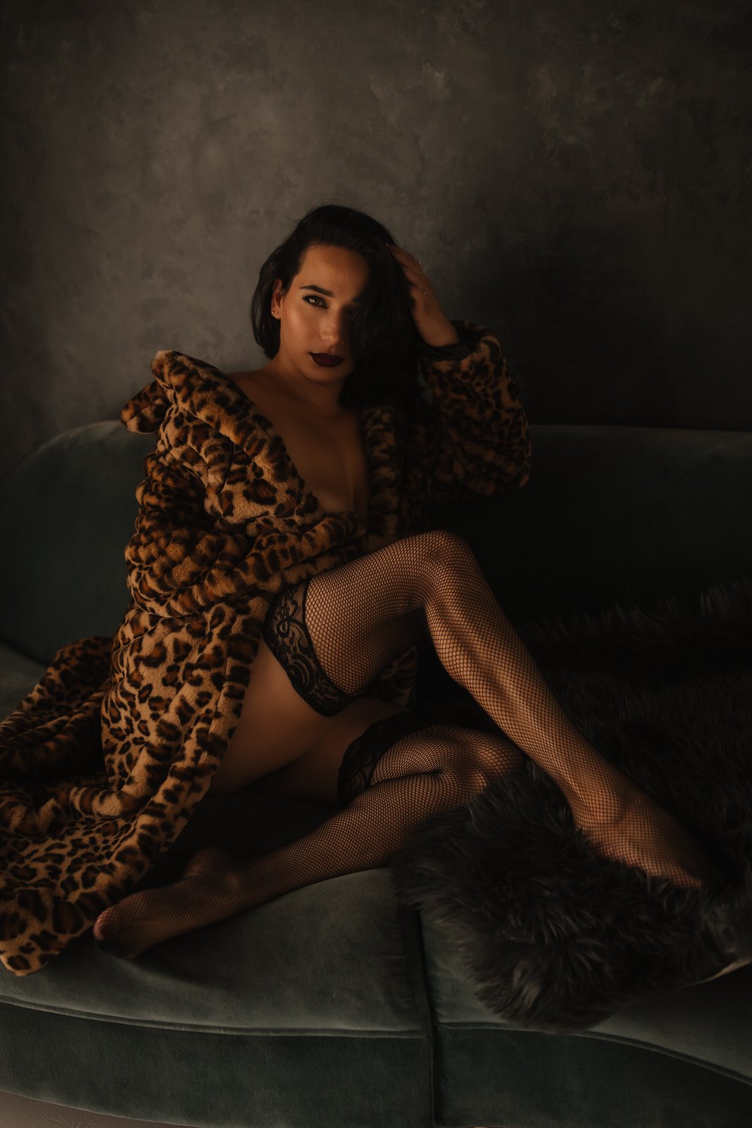boudoir photo of woman in leopard coat with fishnet thigh highs on