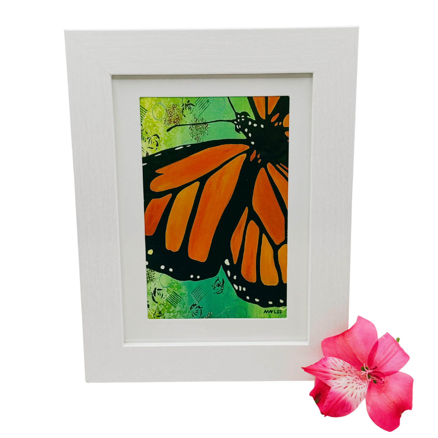 Framed artwork of a monarch butterfly with orange and black wings on a green background, accompanied by a pink flower in the foreground.