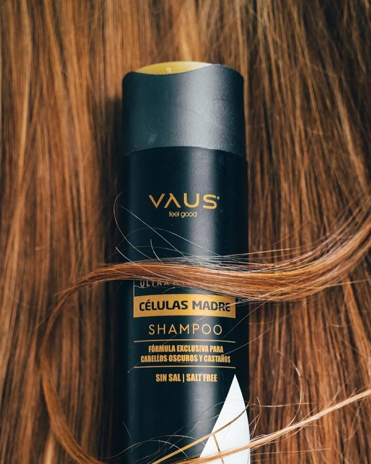 Frasco de shampoo VAUS de fórmula exclusiva para cabelos escuros e castanhos, sem sal, com cabelo castanho ao redor.
