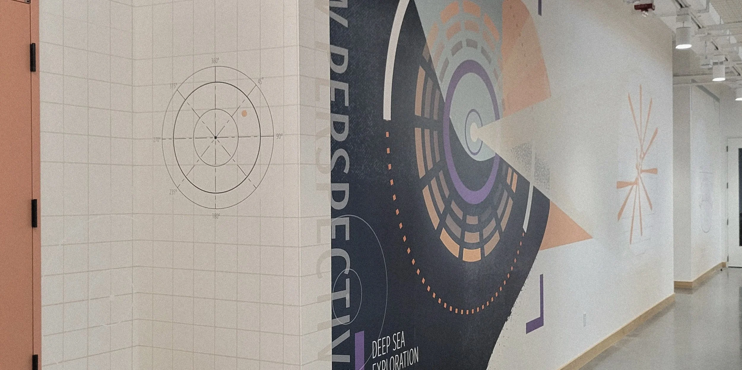 Interior hallway with large wall mural featuring abstract geometric designs, circles, and lines in colors purple, orange, and white, with text including 'Deep Sea Exploration' and other partially visible words.