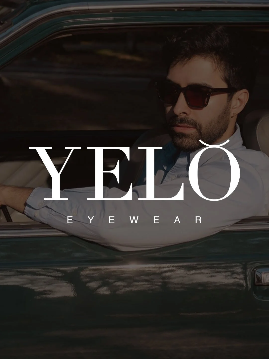 Hombre con gafas de sol en un coche clásico, con logotipo de YELÖ EYewear en primer plano.