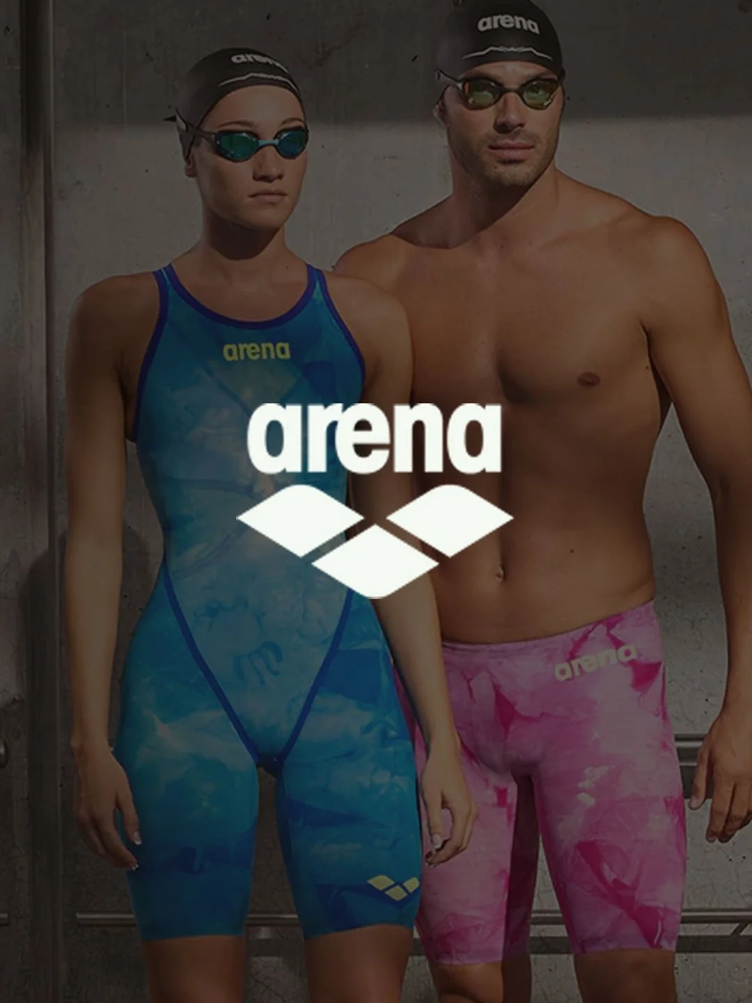 Dos nadadores con gafas y gorros de natación, uno femenino con traje azul y uno masculino con short rosa, de pie junto a una pared de baldosas, con el logo de Arena en el centro.
