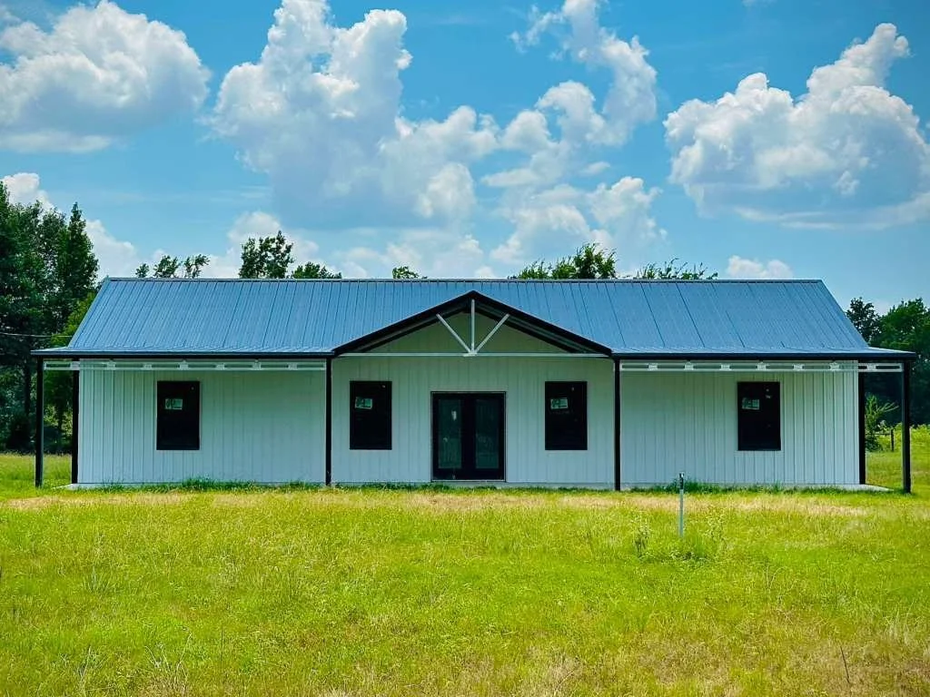 A modern house with white siding and a galvanized metal roof