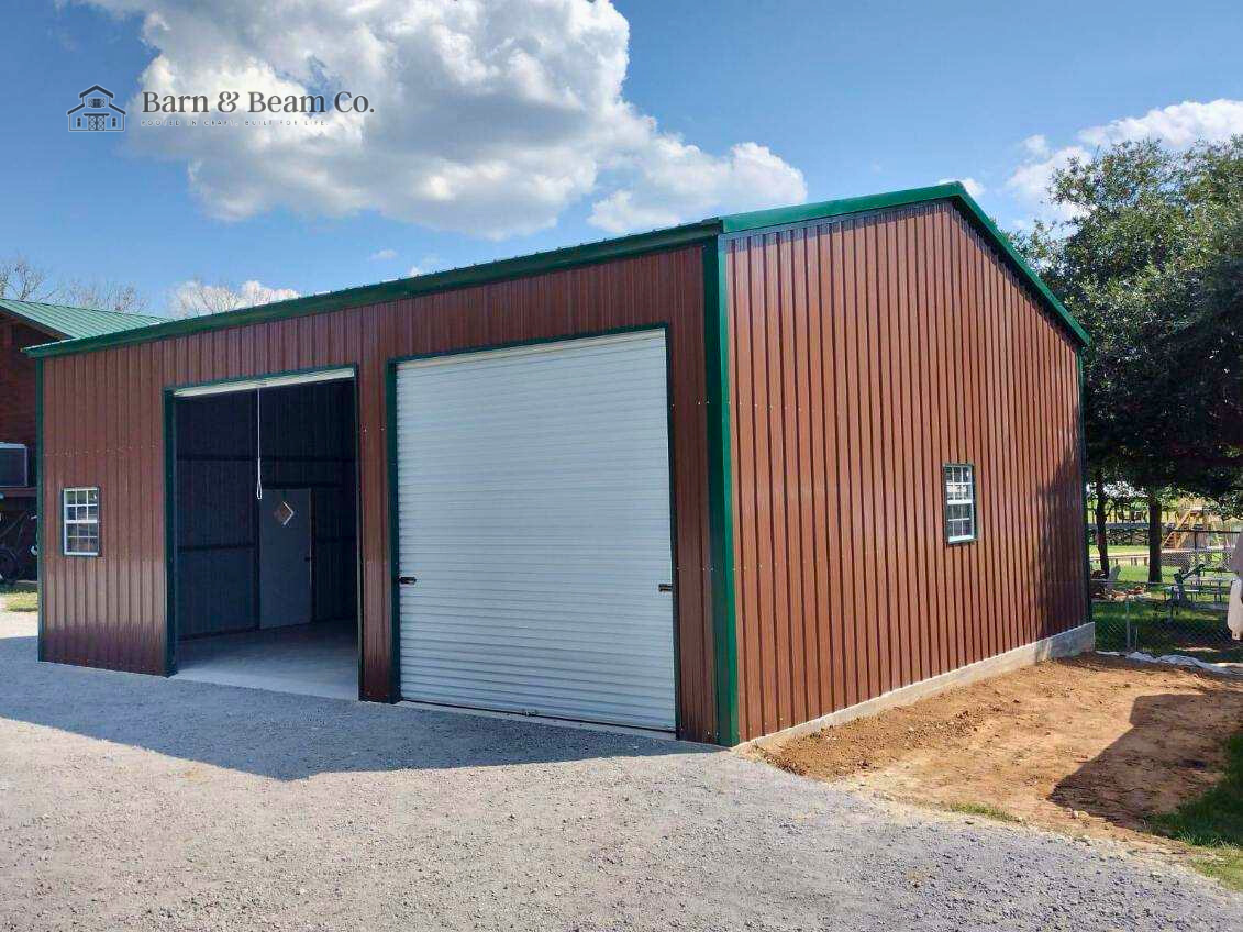 Red metal storage shed with two white roll-up doors, two small windows, green trim, and a gravel driveway in front, located outdoors on a clear day.