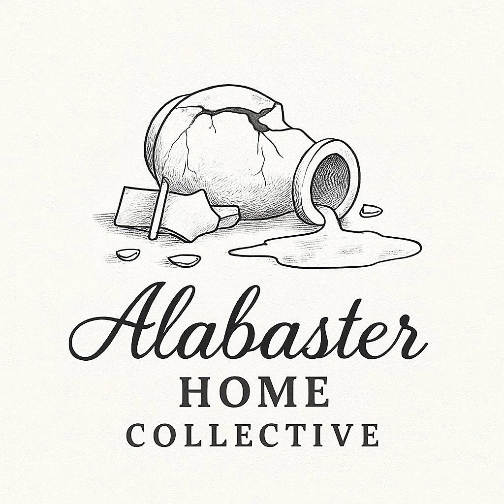 A black and white drawing of a cracked ceramic jar spilled on its side with spilled liquid, rocks, and a small rectangular piece nearby. The word "Alabaster" in cursive script with "Home Collective". Camp Renovation and Design in Columbus, Ohio.