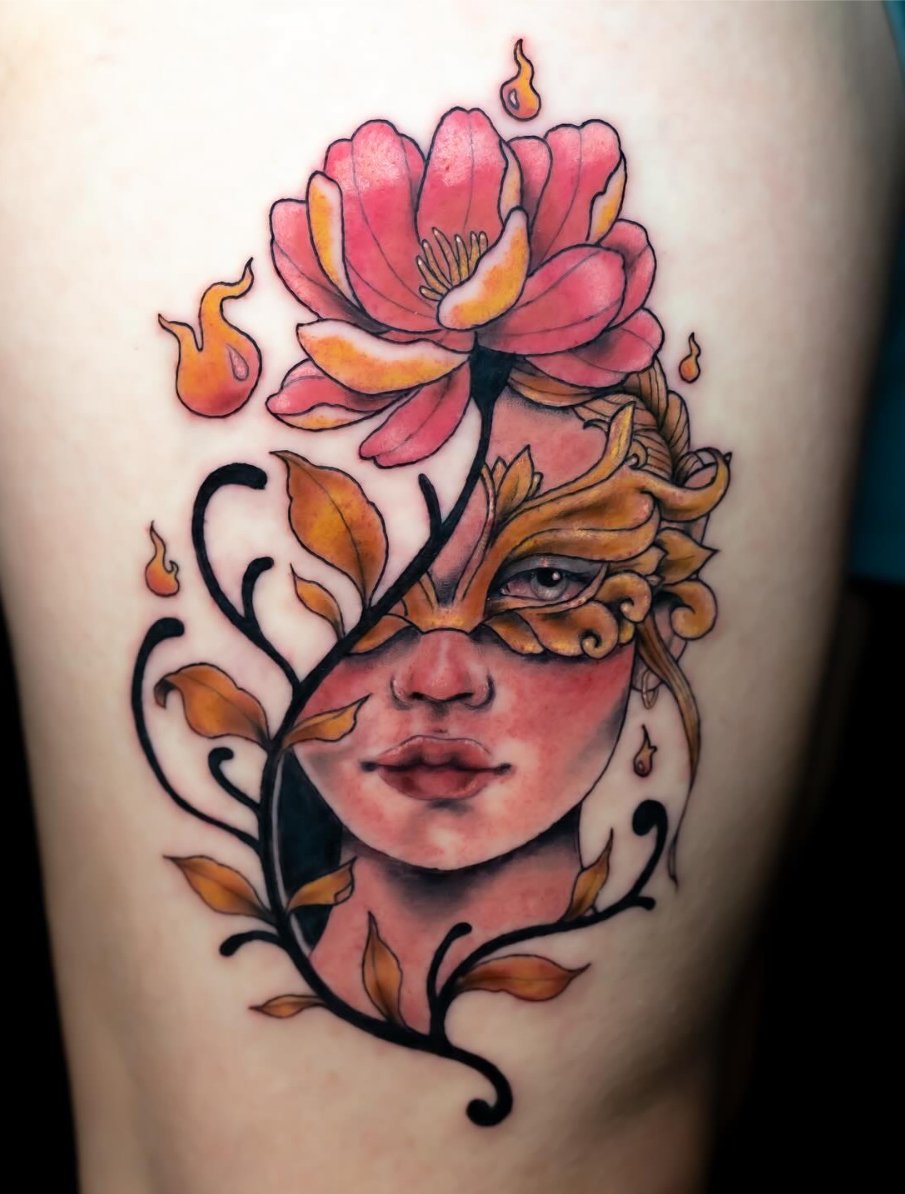 Tattoo of a woman's face with large pink flowers, botanical elements, and flames surrounding her face on skin.