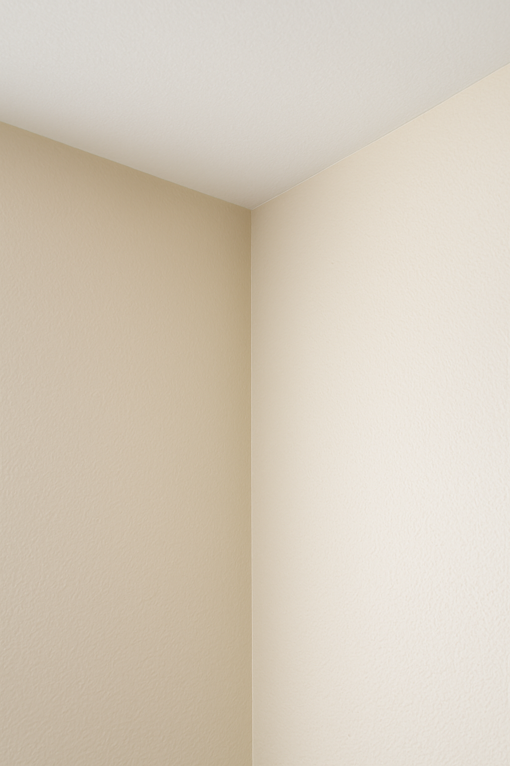 Close-up of a corner of a room with beige walls and a white ceiling. drywall, paint,