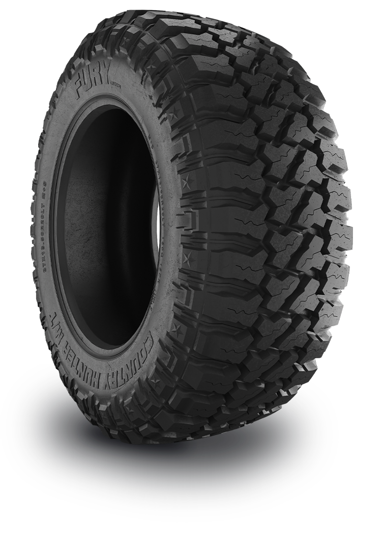 A close-up of a large black off-road tire with deep, rugged treads and the brand name 'Fury' visible on the sidewall.