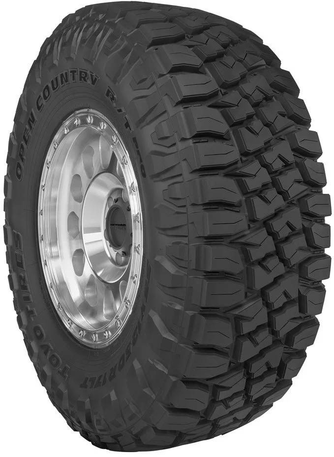 Off-road tire with deep treads mounted on a shiny metal wheel.