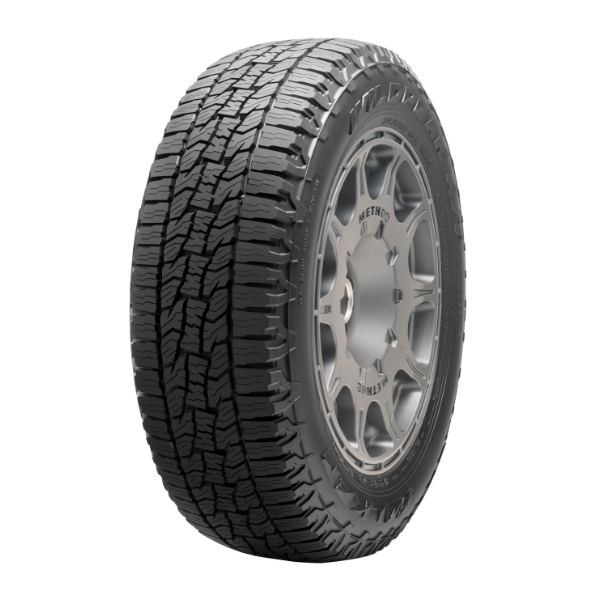 A close-up of a black rubber tire with detailed tread, mounted on a silver alloy wheel.