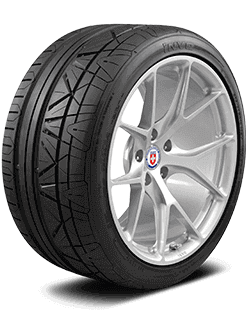 Close-up of a car tire mounted on a silver alloy wheel with a hubcap and a logo in the center.