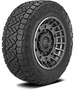 Close-up of a large off-road tire with a rugged tread pattern mounted on a wheel