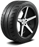 Close-up of a black car tire with a silver alloy wheel.